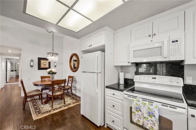 40N Calle Aragon, Laguna Woods, CA 92637 - kitchen with white appliances, dark countertops, a chandelier, and white cabinets