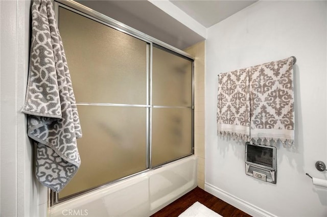 40N Calle Aragon, Laguna Woods, CA 92637 - full bath with baseboards, heating unit, combined bath / shower with glass door, and wood finished floors