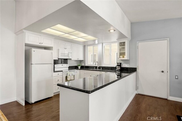 40N Calle Aragon, Laguna Woods, CA 92637 - kitchen with a peninsula, white cabinets, white appliances, and dark wood-style floors