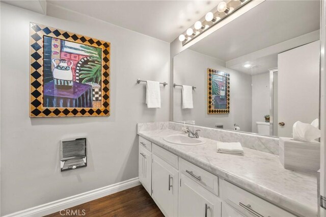 40N Calle Aragon, Laguna Woods, CA 92637 - bathroom with heating unit, baseboards, vanity, and wood finished floors