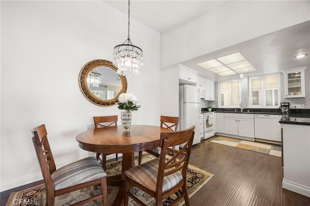 40N Calle Aragon, Laguna Woods, CA 92637 - dining space with baseboards, a chandelier, and dark wood-style floors
