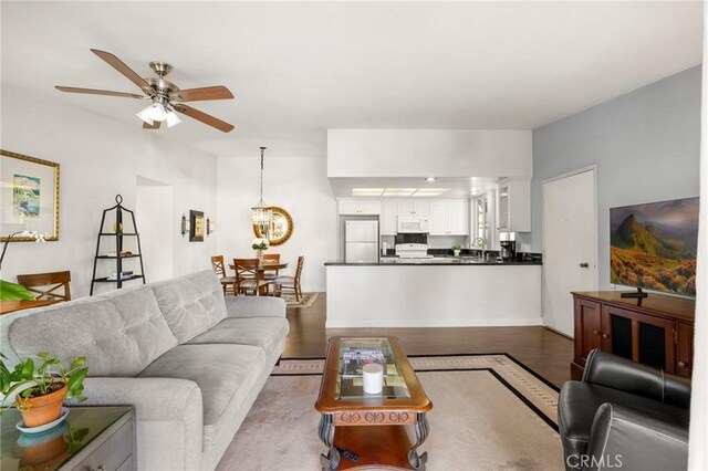 40N Calle Aragon, Laguna Woods, CA 92637 - living room featuring ceiling fan with notable chandelier and wood finished floors
