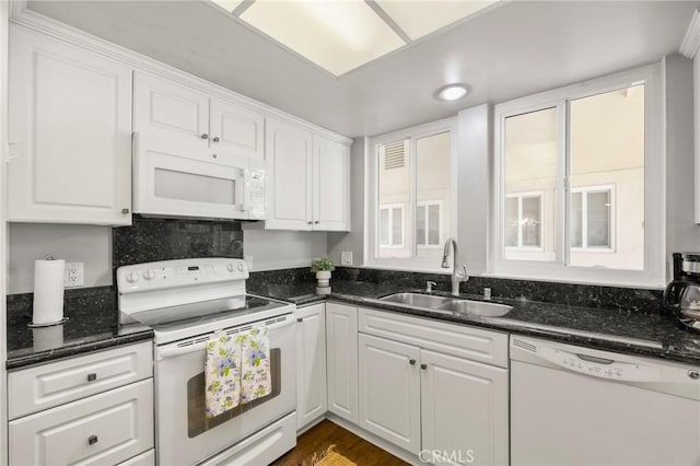 40N Calle Aragon, Laguna Woods, CA 92637 - kitchen with white appliances, white cabinetry, a sink, and dark stone countertops