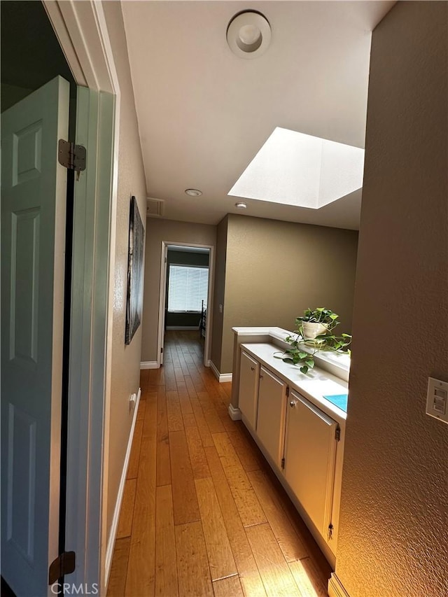 hall with baseboards, recessed lighting, and light wood-type flooring