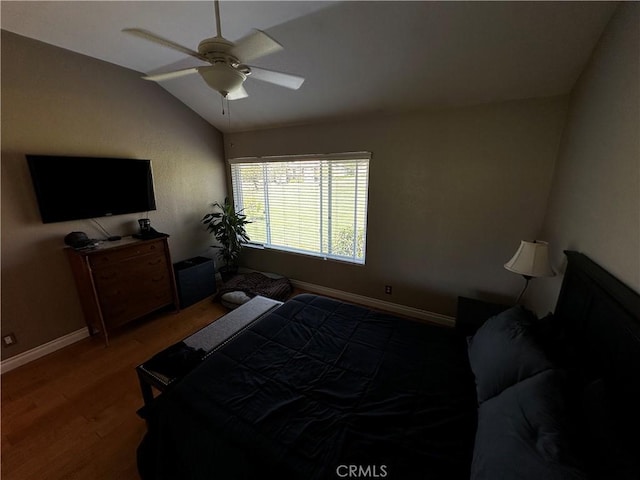 bedroom featuring baseboards, ceiling fan, wood finished floors, and vaulted ceiling