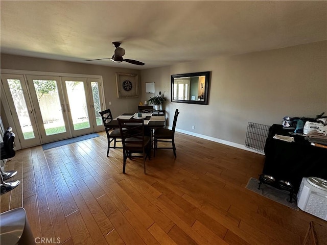 dining area with a ceiling fan, baseboards, french doors, and hardwood / wood-style floors