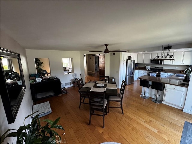 dining room featuring visible vents, ceiling fan, and hardwood / wood-style floors