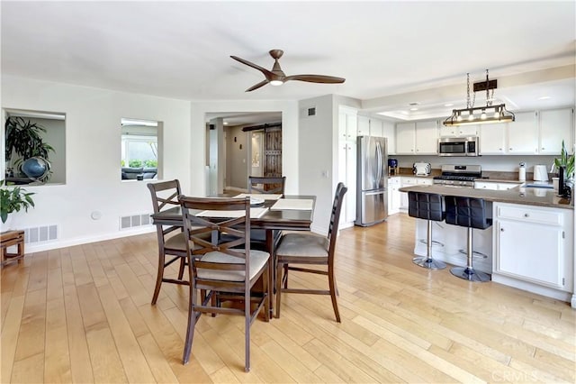 3 Holly Hill Ln, Laguna Hills, CA 92653 - dining room with light wood-type flooring, a ceiling fan, baseboards, and a barn door