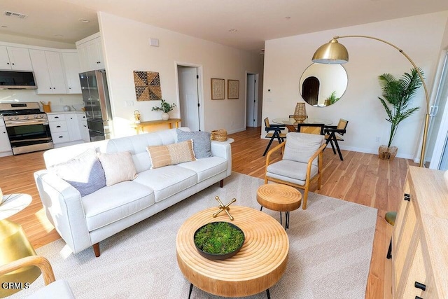 living area with visible vents and light wood-style flooring