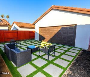 exterior space featuring a tiled roof, fence, outdoor lounge area, and stucco siding