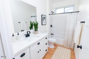 full bathroom featuring vanity, shower / bath combo, toilet, and wood finished floors