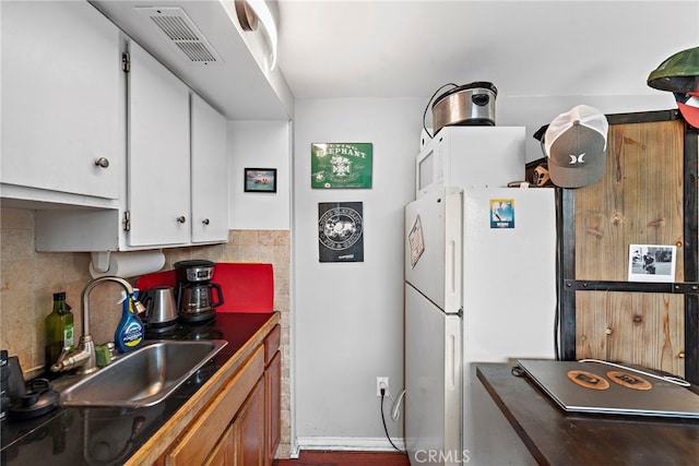 202 Avenida Monterey, San Clemente, CA 92672 - kitchen with freestanding refrigerator, a sink, white cabinets, dark countertops, and tasteful backsplash