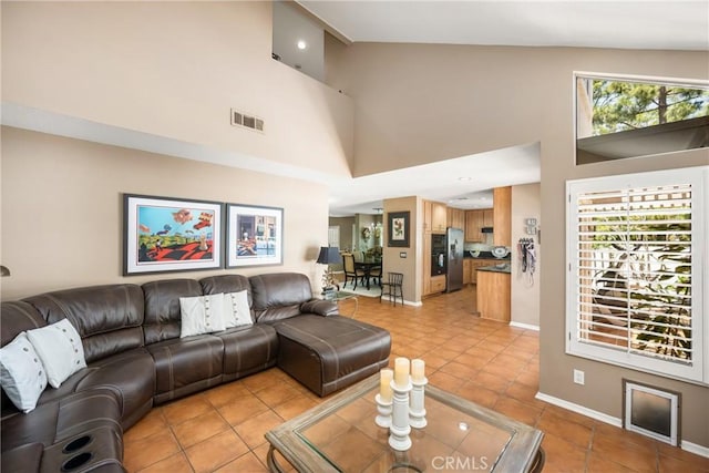 401 E Yale Loop Unit 20, Irvine, CA 92614 - living room featuring a towering ceiling, light tile patterned floors, and baseboards