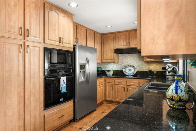 401 E Yale Loop Unit 20, Irvine, CA 92614 - kitchen with black appliances, under cabinet range hood, a sink, dark stone countertops, and backsplash