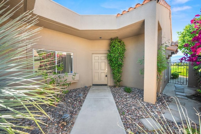 53 Pine Valley Dr, Rancho Mirage, CA 92270 - view of exterior entry with a gate, stucco siding, and a tiled roof