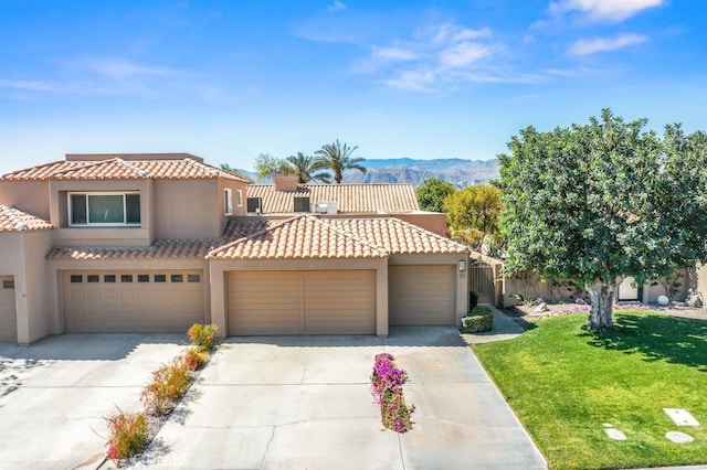 53 Pine Valley Dr, Rancho Mirage, CA 92270 - view of front facade featuring a front yard, stucco siding, a tiled roof, an attached garage, and driveway