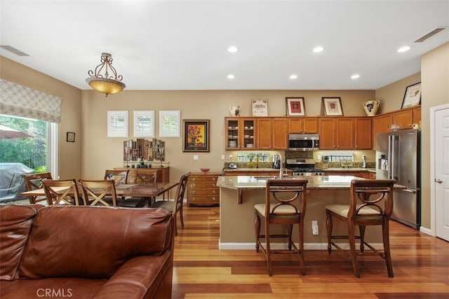 9169 Wooded Hill Dr, Corona, CA 92883 - kitchen featuring appliances with stainless steel finishes, brown cabinetry, a sink, and visible vents