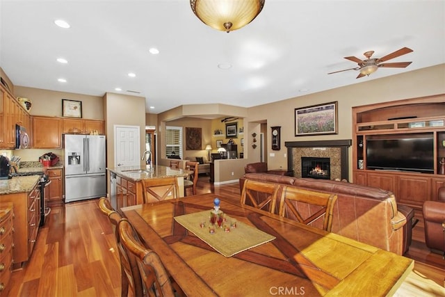 9169 Wooded Hill Dr, Corona, CA 92883 - dining room featuring recessed lighting, ceiling fan, a glass covered fireplace, and light wood finished floors