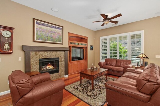 9169 Wooded Hill Dr, Corona, CA 92883 - living room featuring baseboards, a fireplace, a ceiling fan, and wood finished floors