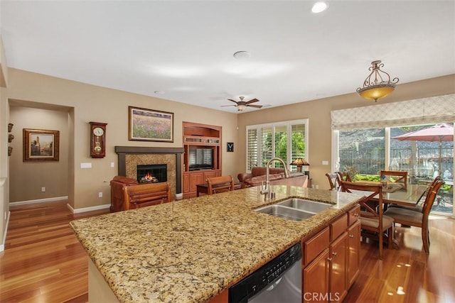 9169 Wooded Hill Dr, Corona, CA 92883 - kitchen with wood finished floors, a fireplace, ceiling fan, a sink, and dishwasher