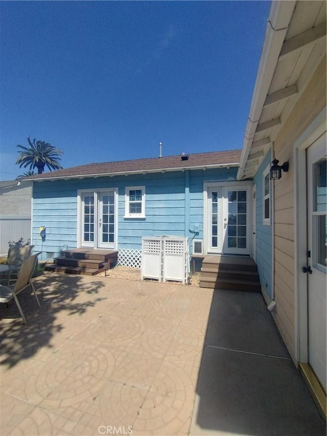 rear view of property with french doors, a patio, and entry steps