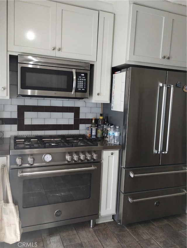 kitchen featuring decorative backsplash, dark wood finished floors, high end appliances, and white cabinets