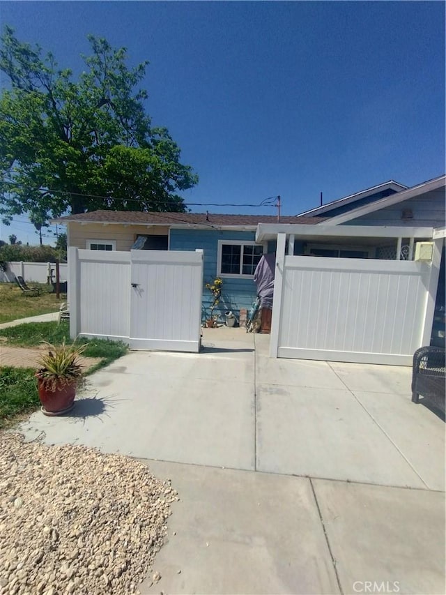 ranch-style home with fence and a gate