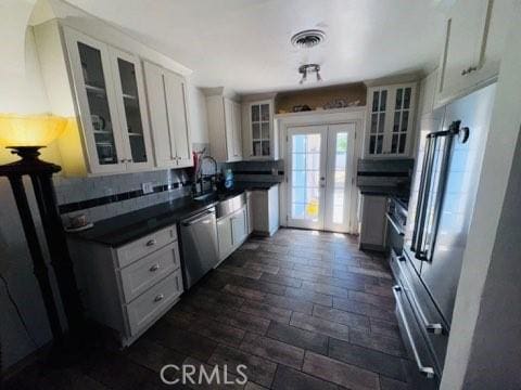 3620 Hoover St, Riverside, CA 92504 - kitchen featuring stainless steel appliances, dark countertops, french doors, glass insert cabinets, and white cabinets