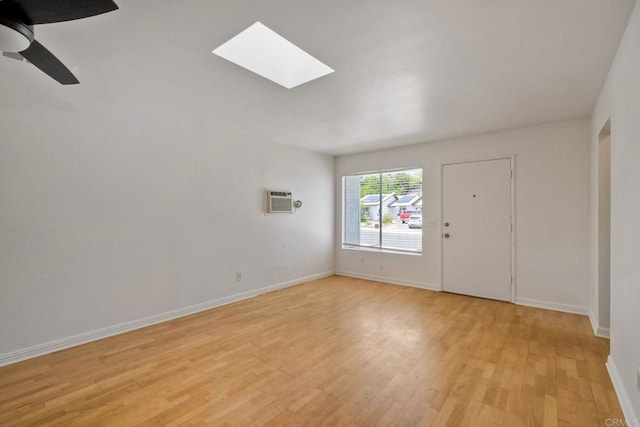4549 Quailridge Dr, Oceanside, CA 92056 - empty room with a skylight, light wood-type flooring, a wall unit AC, and a ceiling fan