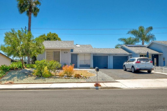 4549 Quailridge Dr, Oceanside, CA 92056 - ranch-style home featuring an attached garage, driveway, solar panels, stucco siding, and roof with shingles