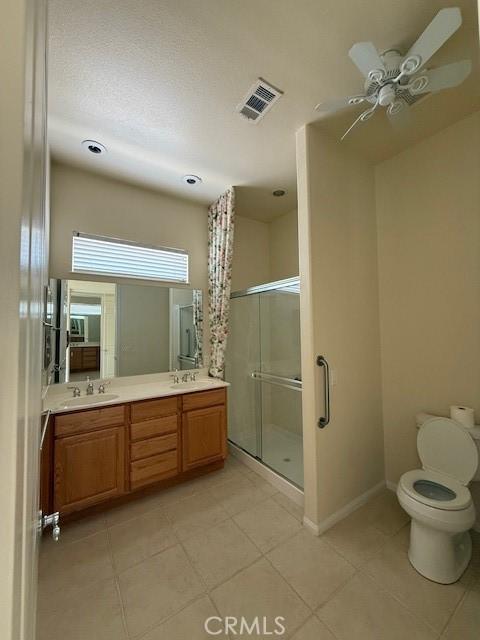 322 Brooklawn Dr, Banning, CA 92220 - bathroom with double vanity, visible vents, tile patterned flooring, a shower stall, and a sink