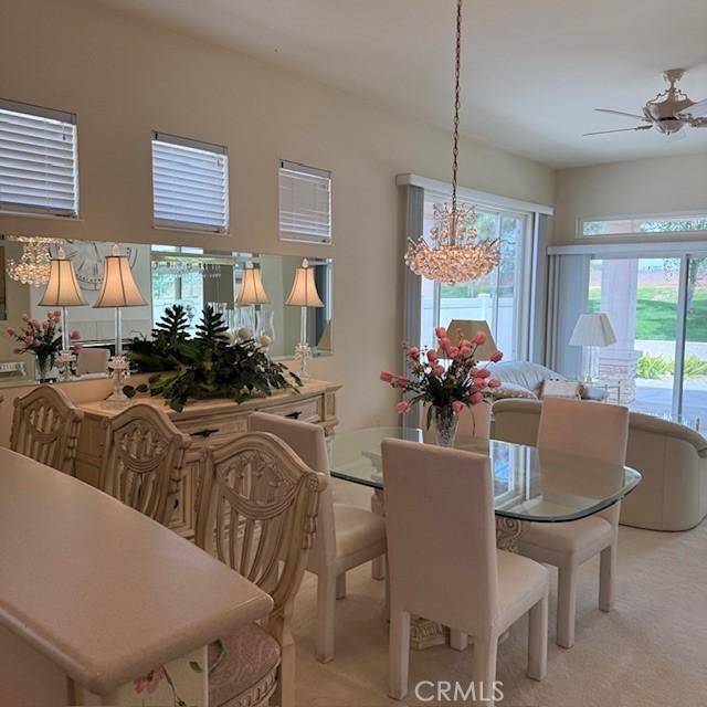 322 Brooklawn Dr, Banning, CA 92220 - dining area featuring light colored carpet and ceiling fan with notable chandelier