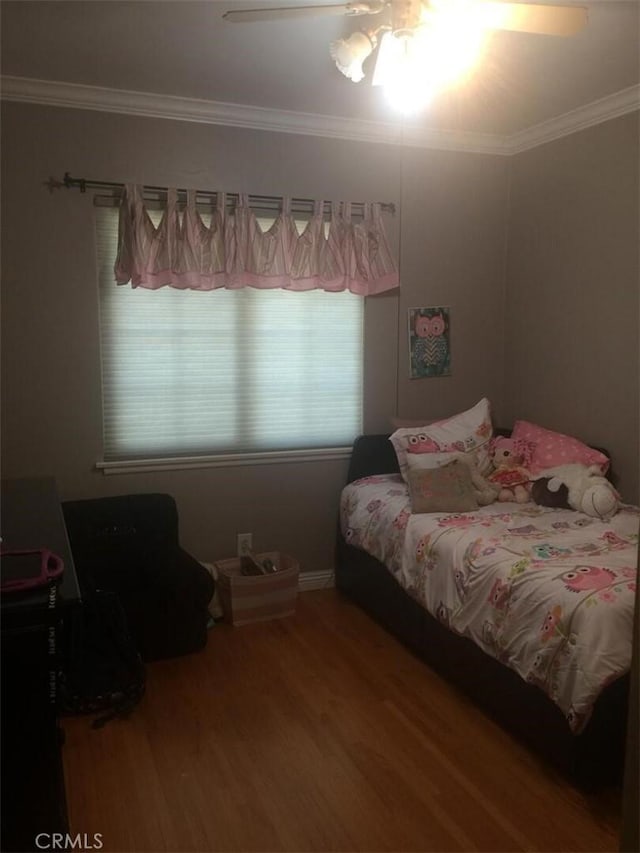 bedroom with a ceiling fan, ornamental molding, and wood finished floors