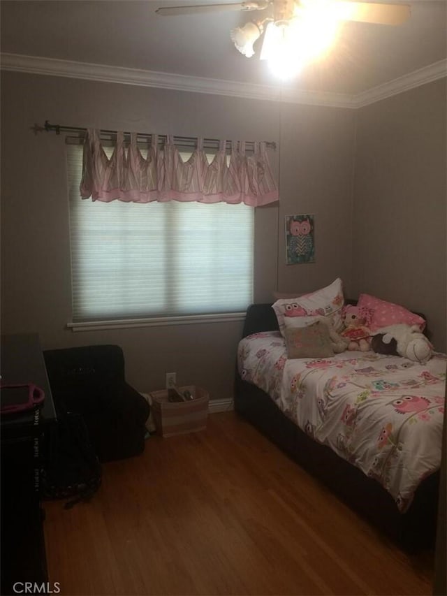bedroom with crown molding, wood finished floors, and a ceiling fan