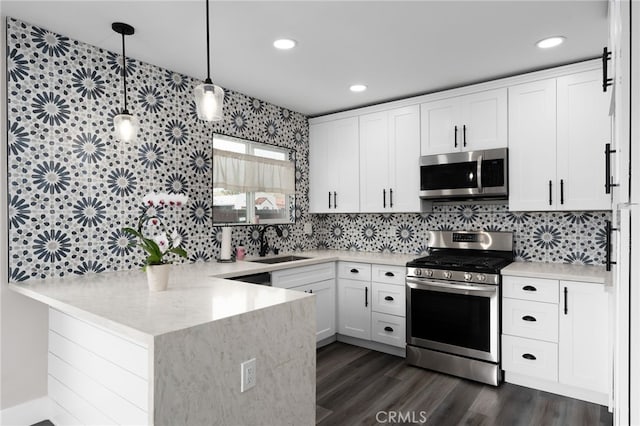 3204 Madison Ave, San Diego, CA 92116 - kitchen with dark wood-style flooring, a peninsula, white cabinetry, a sink, and stainless steel appliances
