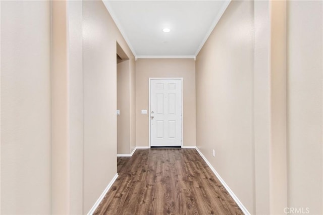 doorway with crown molding, baseboards, and dark wood finished floors