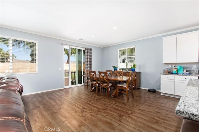 dining room with crown molding, dark wood-style floors, and a wealth of natural light