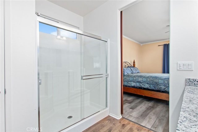 full bathroom with baseboards, connected bathroom, wood finished floors, and a shower stall