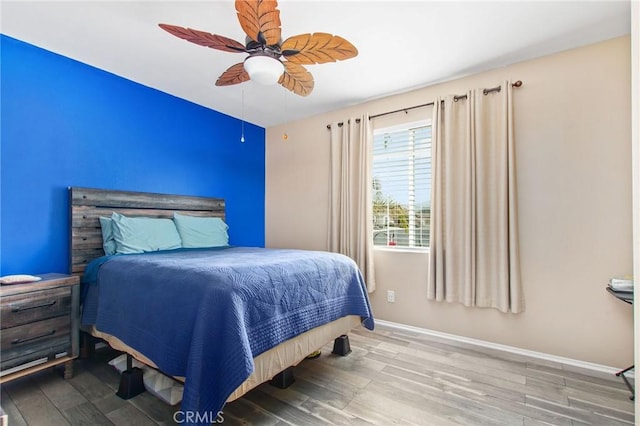 bedroom featuring baseboards, ceiling fan, and wood finished floors