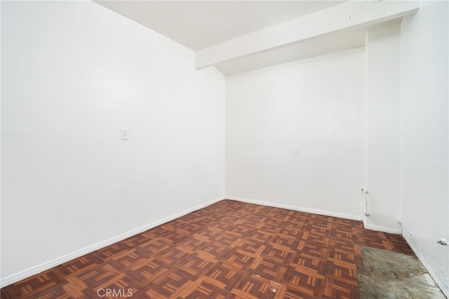 spare room featuring baseboards and lofted ceiling with beams