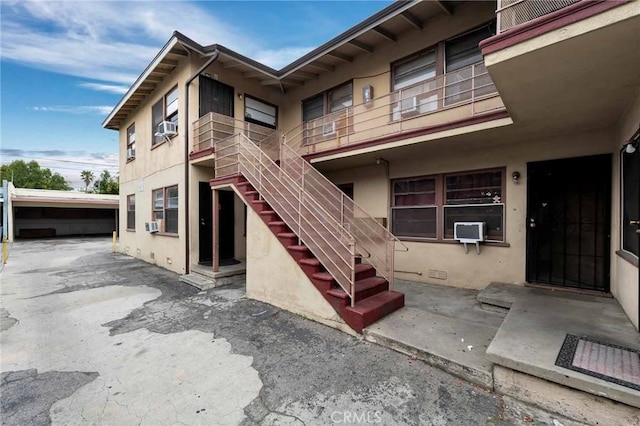 exterior space featuring a patio, cooling unit, and stucco siding