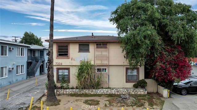 view of property with stucco siding and stairway