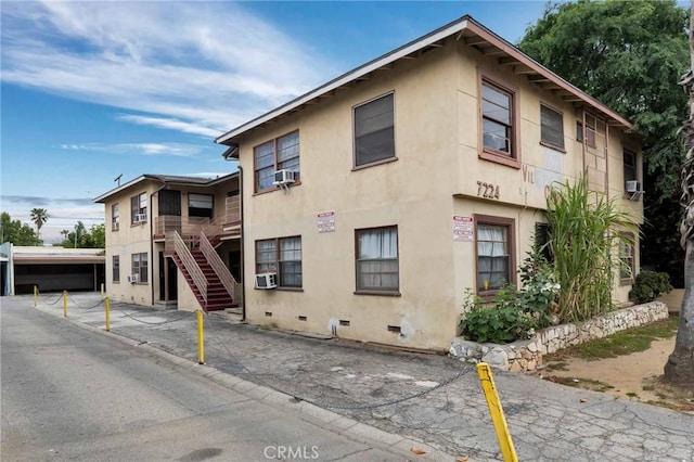 view of property with stairway and cooling unit