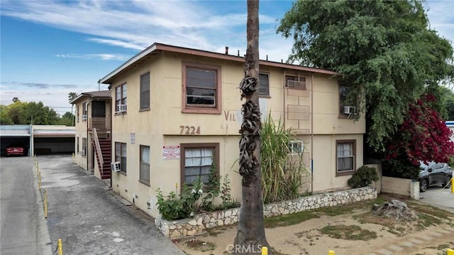 exterior space with stairway and stucco siding