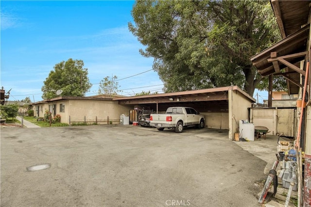view of parking with driveway and a detached carport