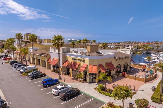 view of building exterior featuring a water view and uncovered parking