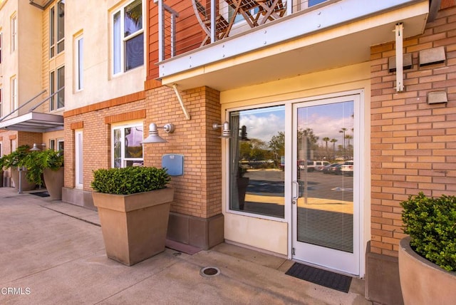doorway to property featuring brick siding