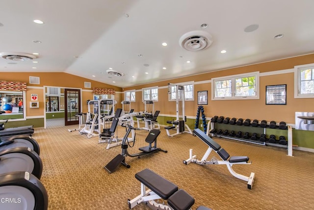 exercise room featuring visible vents, carpet, lofted ceiling, and a wealth of natural light