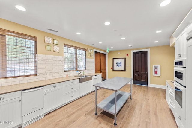 kitchen featuring a sink, recessed lighting, backsplash, and white appliances