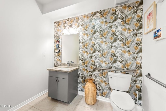bathroom with toilet, wallpapered walls, and baseboards